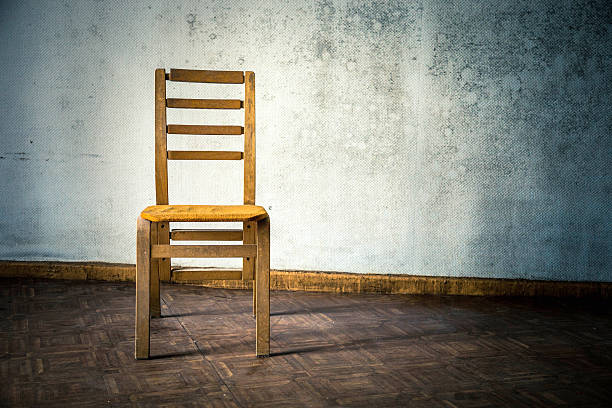 istock Wooden chair against an old grey wall 181119445