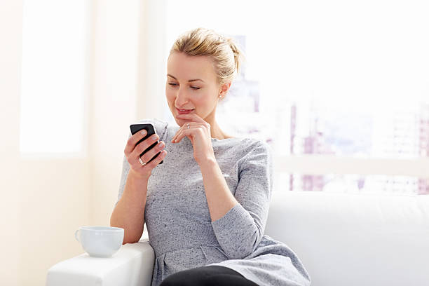 istock Young attractive woman using cell phone at home 181120100