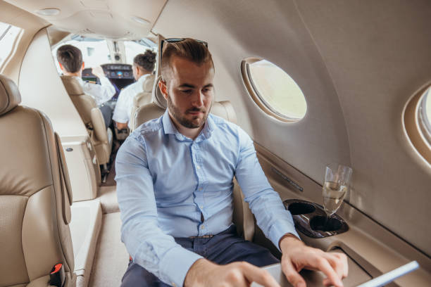 istock Young businessman in a private jet plane using digital tablet 1811205639