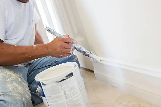 Photo of painter painting wood trim