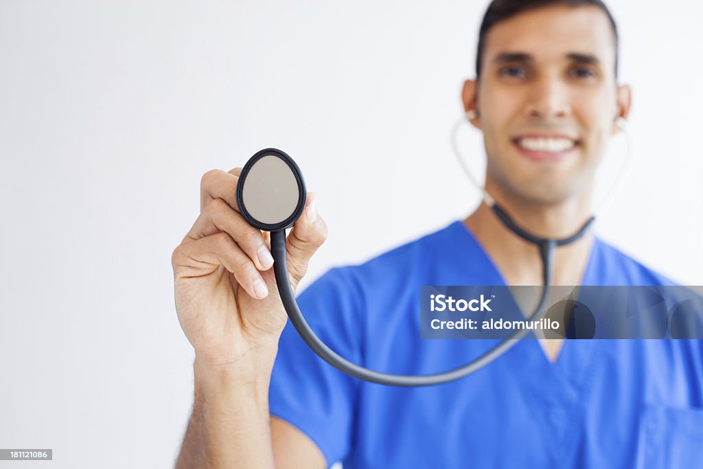 Joven sosteniendo un estetoscopio médico - Foto de stock de 30-39 años libre de derechos