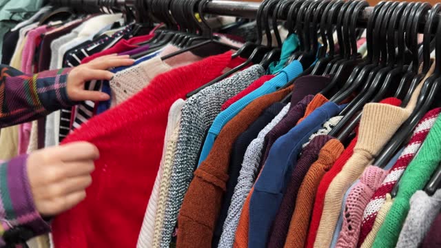 Woman buys second-hand clothes in a thrift store