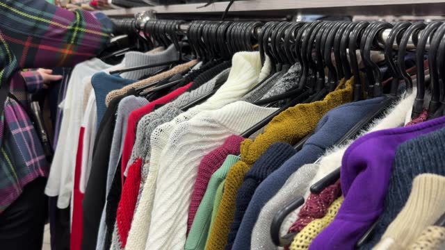Woman buys second-hand clothes in a thrift store