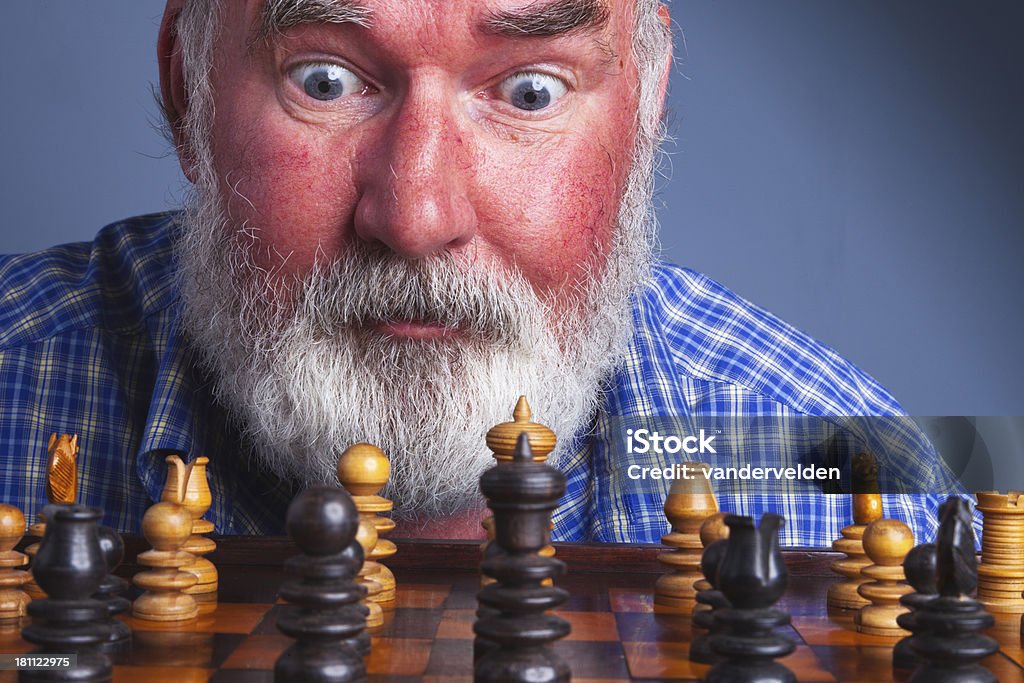 Chess Player An elderly chess player has a flash of inspriation as he contemplates his next move. 60-69 Years Stock Photo