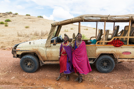 Two maasai men in traditional dress in front of safari jeepSee also my LB: