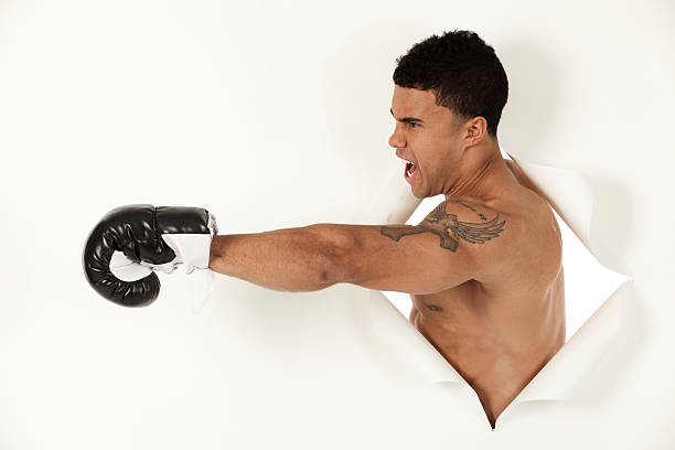 uomo boxer con un pugno da un foro di carta - human mouth paper screaming hole foto e immagini stock