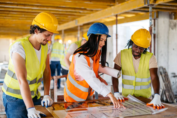 istock Female Engineer Showing The Blueprint To The Construction Workers On A Construction Site 1811252661