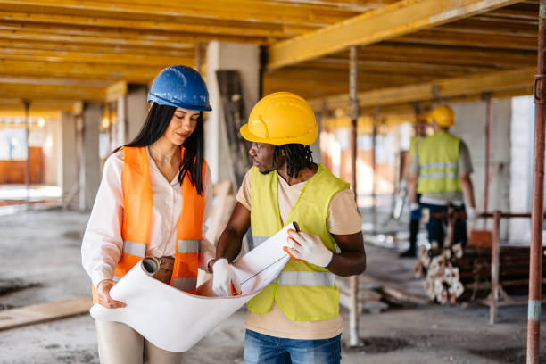 istock Female Engineer Showing The Blueprint To A Construction Worker On A Construction Site 1811261587