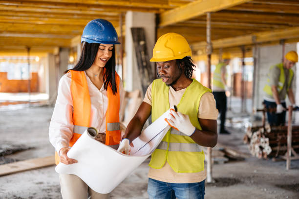 istock Female Engineer Showing The Blueprint To A Construction Worker On A Construction Site 1811267724