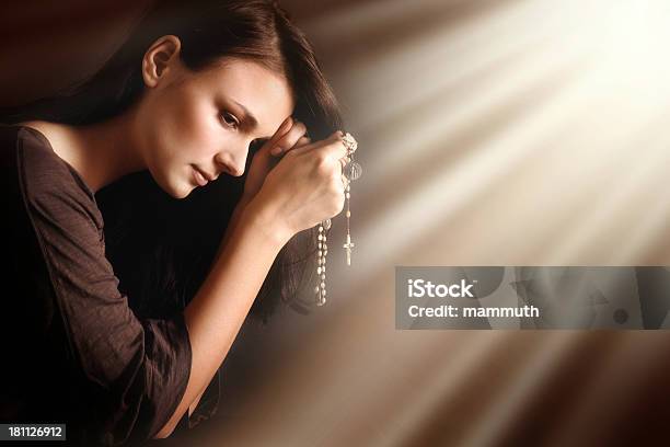 Modlić Się Młoda Kobieta W Divine Światła - zdjęcia stockowe i więcej obrazów Paciorki różańca - Paciorki różańca, Modlić się, Krzyż - Akcesoria religijne