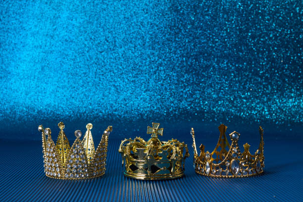 istock Epiphany Day or Dia de Reyes Magos concept. Three gold crowns on blue sparkling background 1811274128