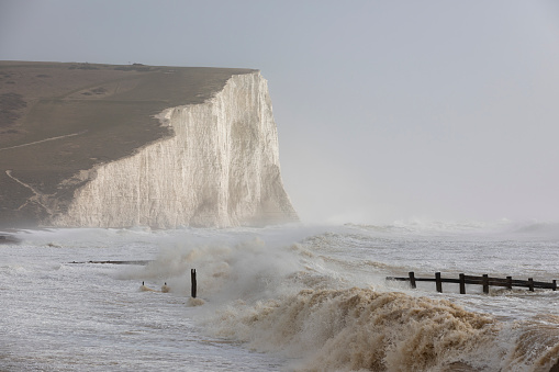 The Seven Sisters white cliffs meet the English channels crashing waves. Sussex, UK