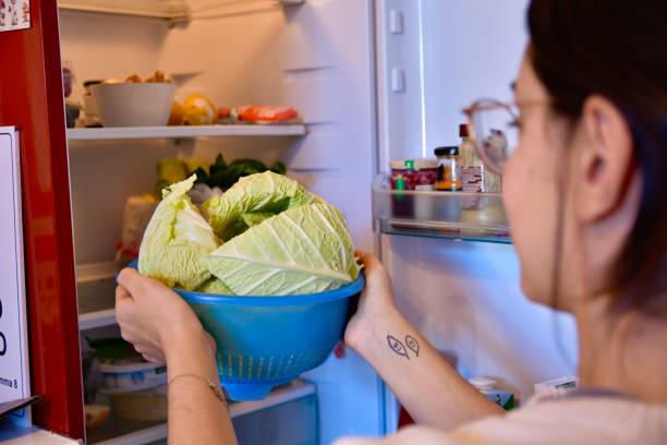 istock Girl puts vegetables in the refrigerator 1811275563