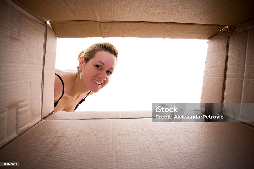 Jovem mulher feliz Olhando para a caixa de papelão. - Royalty-free Caixa Foto de stock