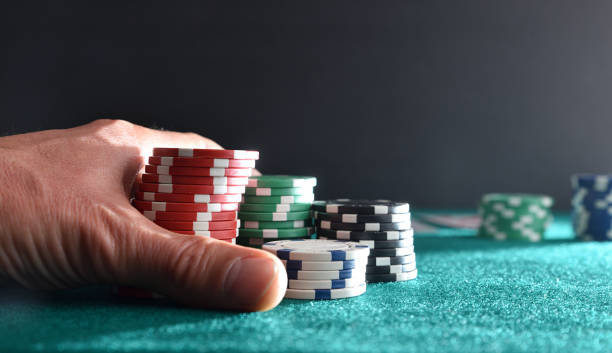 istock Hand betting game chips on mat and isolated dark background 1811286390
