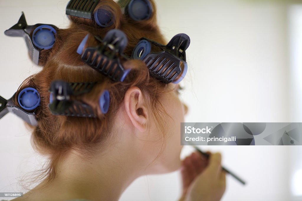 Hair rollers Woman with hair rollers applying make up. Selective focus. Adult Stock Photo