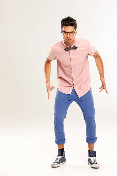 Portrait of young man nerd with finger gun posing over white background