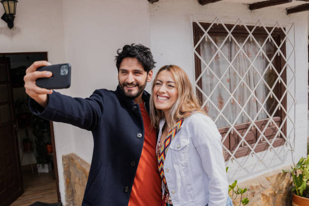 istock Couple taking a selfie using a mobile phone outdoors 1811297675
