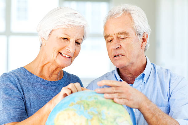 istock Senior Couple Choosing Travel Destination On Globe 181130736