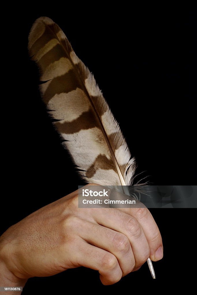 Inspiration A hand with a feather pen isolated on black. Much space for copy Antique Stock Photo