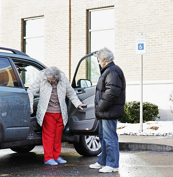 istock Elderly Woman Backing Into Car Front Seat 181130943