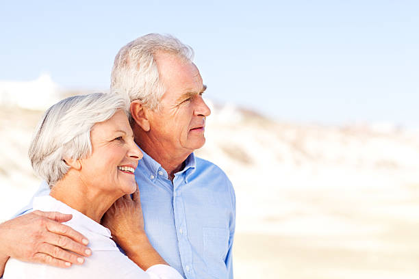 istock Senior Man Standing With Arm Around Woman At Beach 181131781
