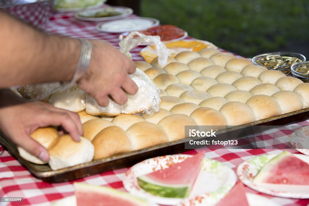 Cibo e bevande: Persone preparare la cena a buffet a base di panini all'aperto - Foto stock royalty-free di A quadri