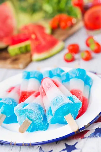 Homemade red-white-and-blue popsicles on an outdoor table.