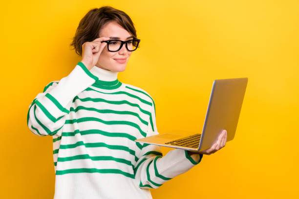 istock Photo of positive smart lady wear striped pullover spectacles texting modern gadget isolated yellow color background 1811331588