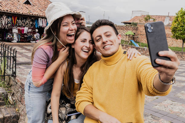istock Tourist friends taking a selfie using mobile phone outdoors 1811332655