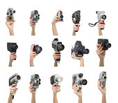 Various video cameras in human hand on white background