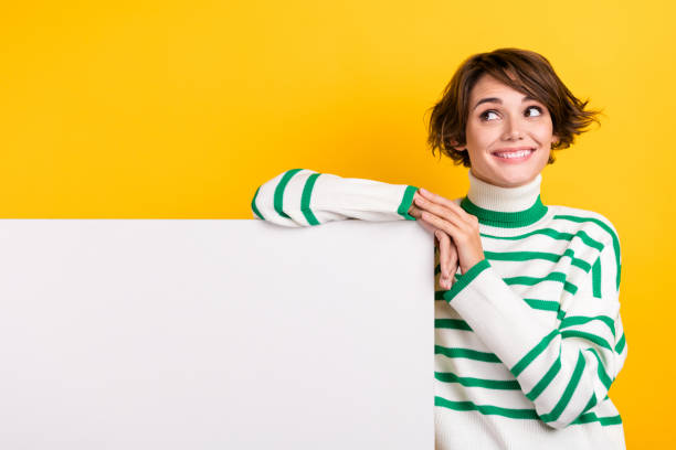 Photo of nice lady dreaming folded hands over whiteboard look interested empty space presentation ad isolated on yellow color background