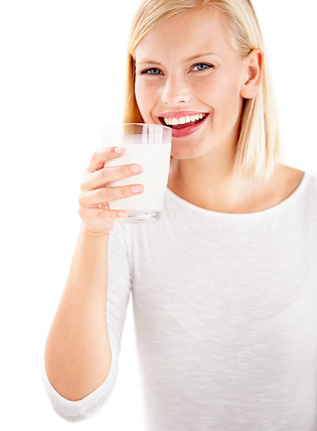 breakfast is prepared on a blurred background of green foliage: a glass of milk and chocolate and vanilla muffins. the concept of a delicious and healthy breakfast