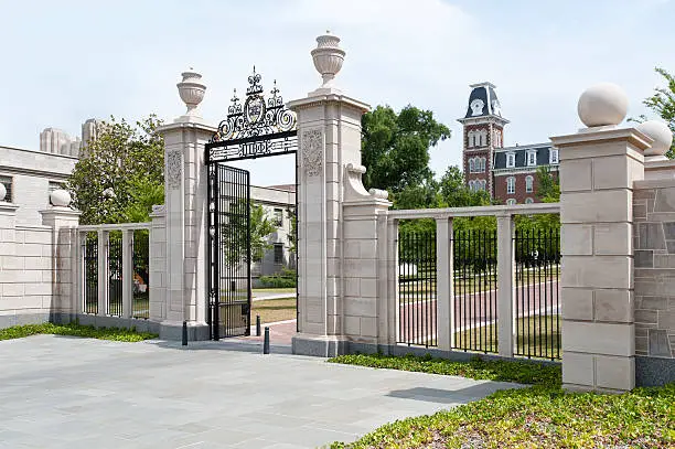 Shot from Maple Street. Centennial Gate entrance to campus of University of Arkansas. One tower of Old Main can be seen in background.