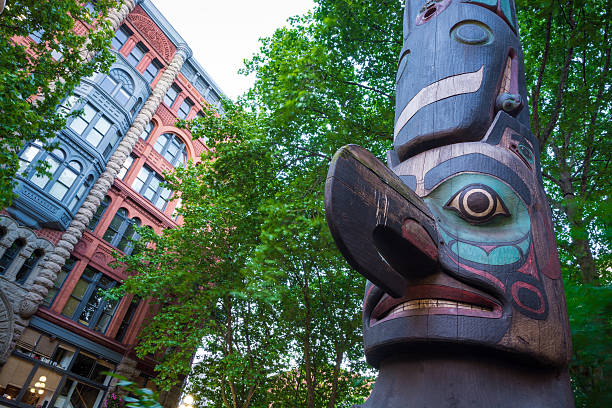 Totem pole at Pioneer Square in Seattle, WA Totem pole at Pioneer Square in Seattle, WA with the Pioneer Building in the background, which was originally constructed in 1892.  indigenous north american culture photos stock pictures, royalty-free photos & images
