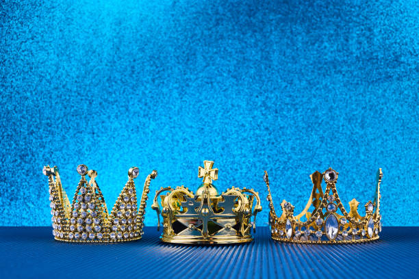 istock Epiphany Day or Dia de Reyes Magos concept. Three gold crowns on blue sparkling background 1811350154