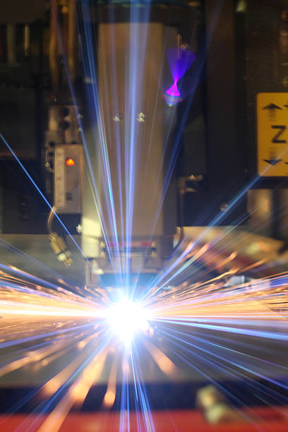 Arc flash of a laser cutting machine as it works through a piece of steel. The laser unit is blured in the background with focus on the flash.
