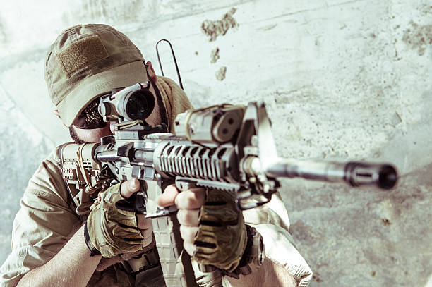 Young Caucasian Modern Army Soldier Aiming with Assault Rifle stock photo