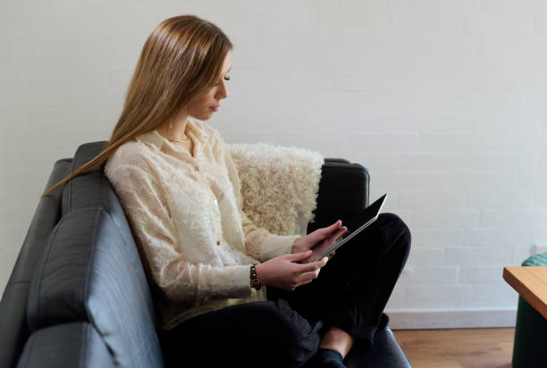 istock Side view of young woman with digital tablet in sofa 1811362997
