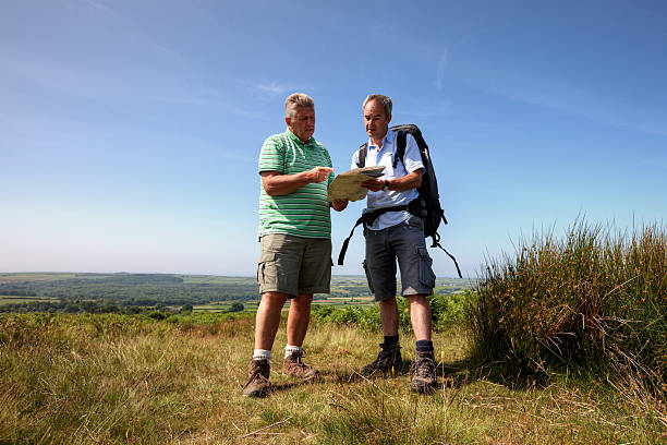 dos hombres maduros excursionismo en el campo - map uk hiking reading fotografías e imágenes de stock