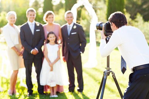 Hombre tomando familiar en boda al aire libre photo