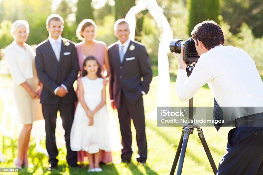 Uomo fotografare famiglia al matrimonio all'aperto - Foto stock royalty-free di Fotografo