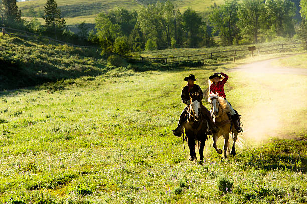 istock Cowboys: Wranglers ride horses through pasture. 181136647
