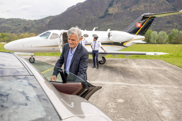 istock Chauffeur opening car door, private jet in the background 1811371272