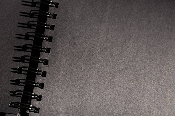 black photo album / spiral notebook on black background