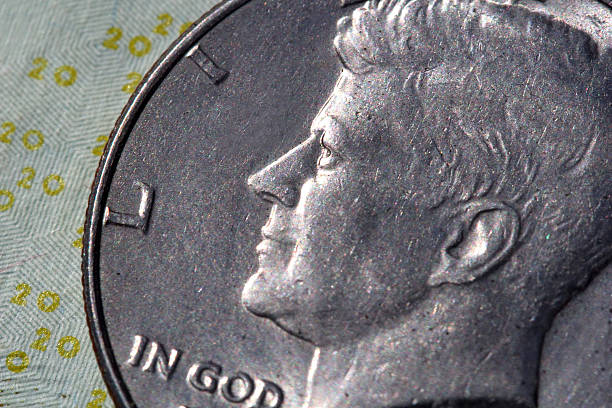 Black and white image of a pile of John F. Kennedy half dollars.