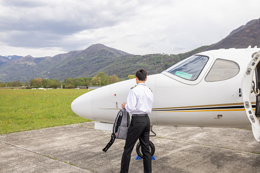 Males pilots preparing private jet for flight