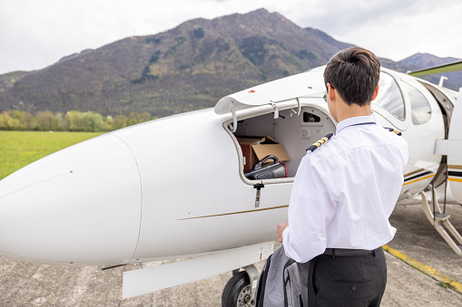 Males pilots preparing private jet for flight