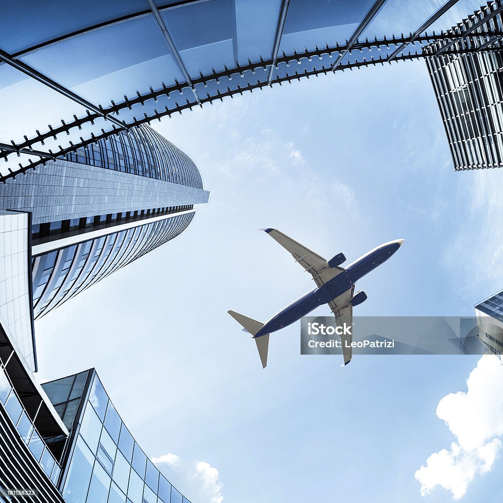 Avión por encima del distrito financiero de la ciudad - Foto de stock de Avión de pasajeros libre de derechos