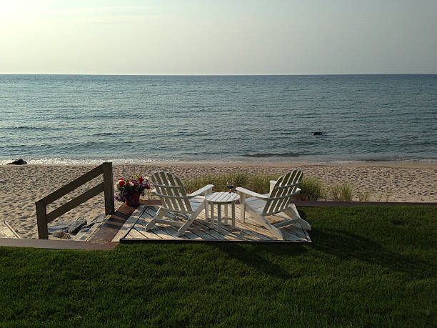 Two Chairs Two chairs facing Lake Michigan with a glass of red wine sitting on a table in between. charlevoix photos stock pictures, royalty-free photos & images